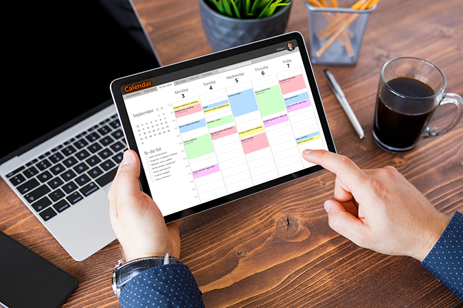 Man using calendar app on tablet at work