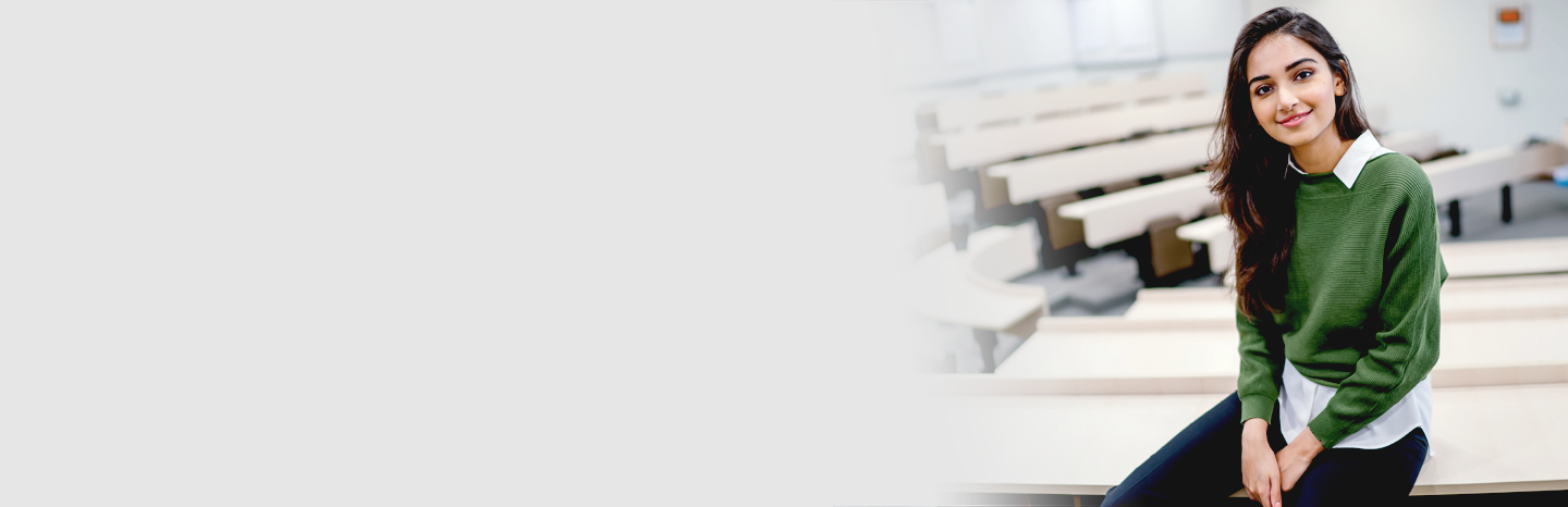 Photo of attractive young man wearing eyeglasses holding smartphone while working on laptop in city cafe outdoors