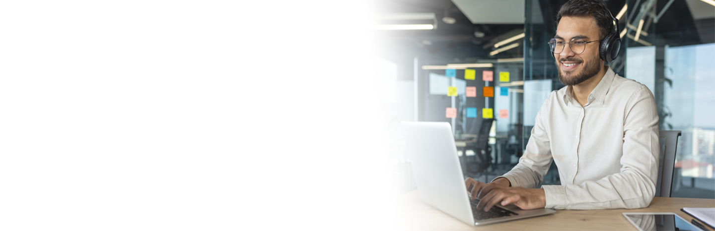 Young man with headphones on laptop working